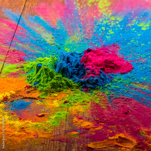 Abstract colorful Happy Holi background. Color vibrant powder on wood. Dust colored splash texture. Flat lay holi paint decoration