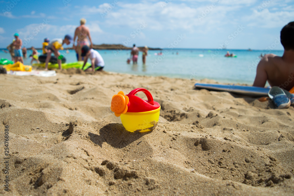 Kid toy forgotten on sand at beach background