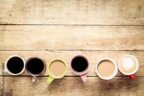 фотографія Many multicolored cups with coffee and coffee drinks lined up on a wooden background