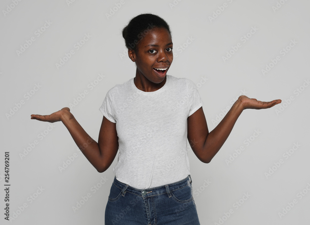 beautiful young African woman smiling over grey background beautiful young African woman smiling over grey background