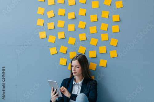 Young businesswoman using digital tablet, sitting under data cloud photo