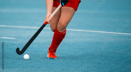 hockey player woman with ball in attack playing field hockey game photo