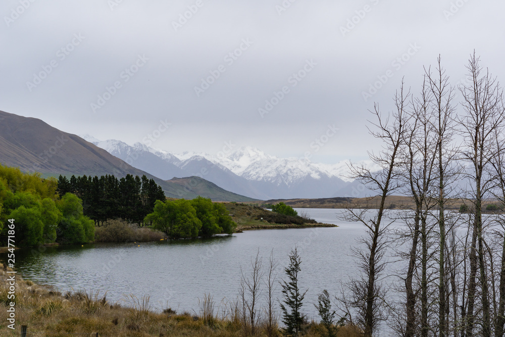 lake in the mountains, mountains on the horizon covered by snow, foggy landscape