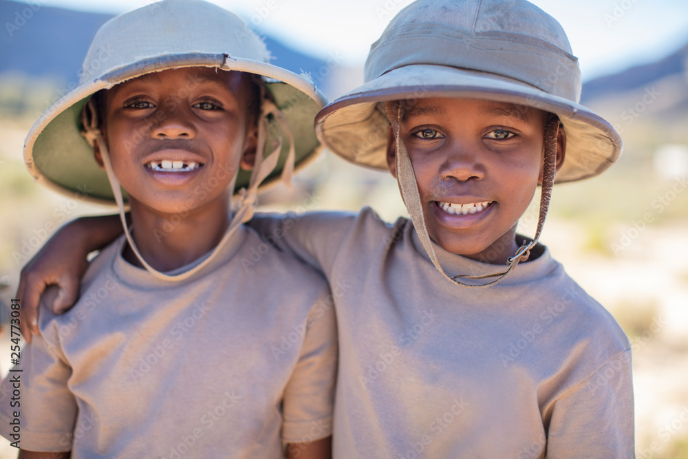 Portrait of two smiling boys embracing wearing pith helmet Portrait of two smiling boys embracing wearing pith helmet