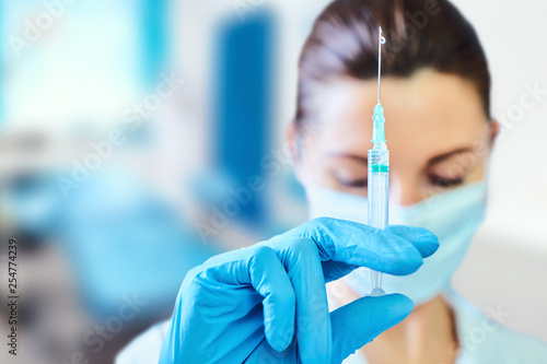 healthcare and medicine concept - close up of female doctor in surgical mask with syringe
