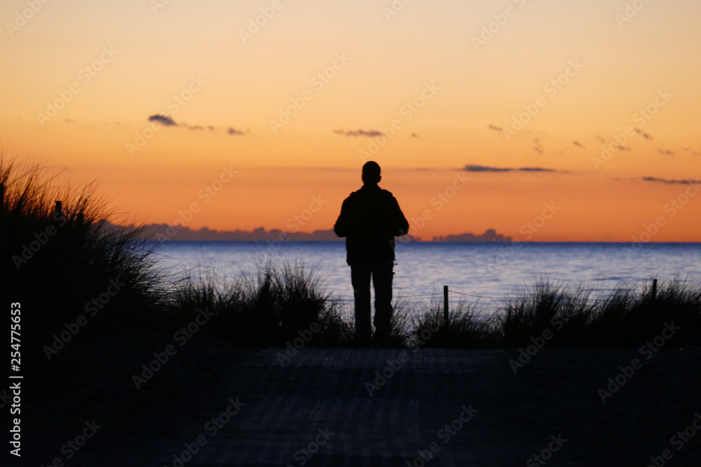 Einsamer Mann am Meer bei Sonnenuntergang