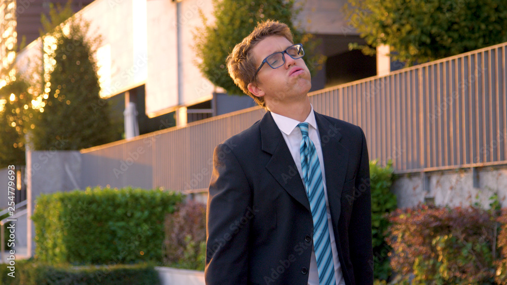 CLOSE UP: Anxious yuppie exhales while walking back home from work at sunset. CLOSE UP: Anxious yuppie exhales while walking back home from work at sunset.