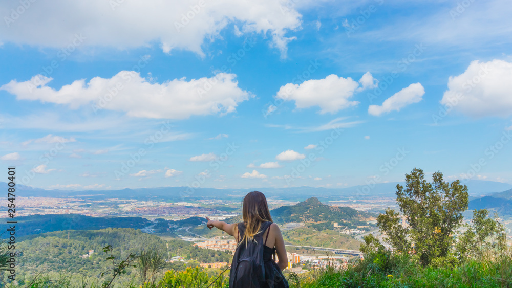 Chica joven señalando al horizonte desde la naturaleza hacia un panorama Chica joven señalando al horizonte desde la naturaleza hacia un panorama