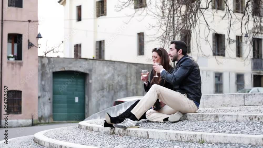 Couple enjoying a glass of wine at sunset in the city. Couple enjoying a glass of wine at sunset in the city.