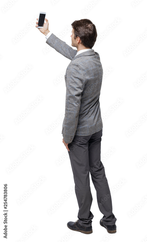 Back view of a business man in a suit making a selfie Back view of a business man in a suit making a selfie