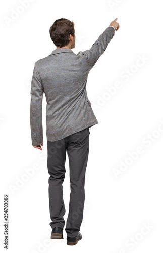 Back view of walking pointing business man.