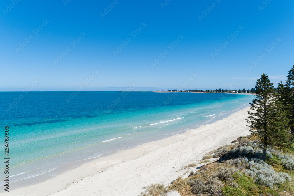 Aerial view over sandy white beach in summer with stunning turquoise blue ocean