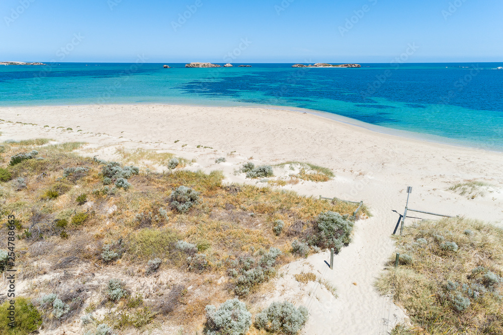 Aerial view over sandy white beach in summer with stunning turquoise blue ocean