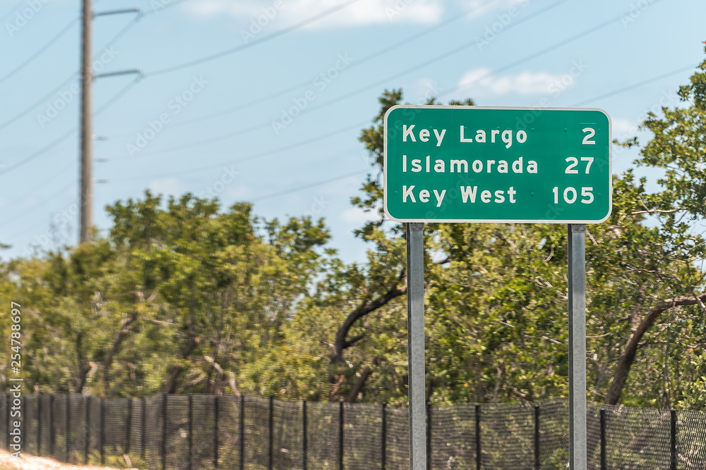 Green road sign for Key Largo, Islamorada and Key west island along Overseas highway in Florida isolated on street Green road sign for Key Largo, Islamorada and Key west island along Overseas highway in Florida isolated on street