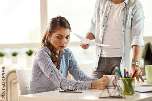 Bild auf Leinwand Sad businesswoman being scolded by her boss in the office.