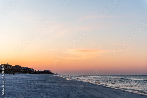 Dreamy pastel orange dark sunrise in Santa Rosa Beach, Florida with coastline coast holiday homes in panhandle with ocean gulf of mexico waves crashing