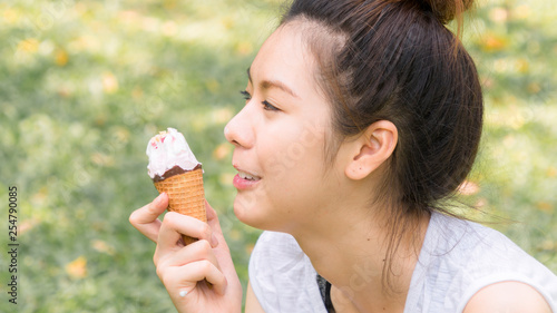 cute girl eat ice cream in close up face feeling delicious photo