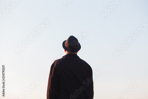 Man with hat looking at sky