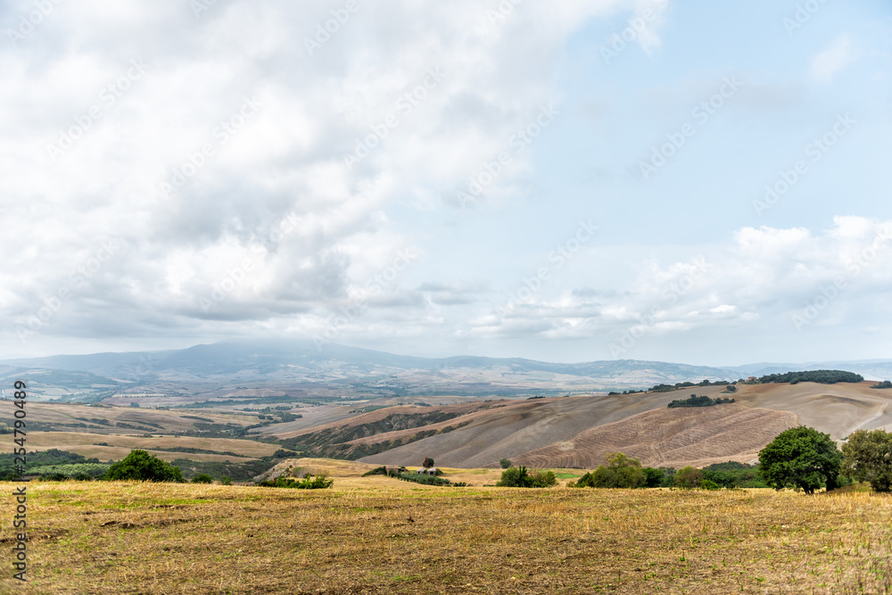 Val D'Orcia countryside in Toscana Tuscany, Italy with rolling plowed hills and villas with farm landscape idyllic picturesque meadow fields