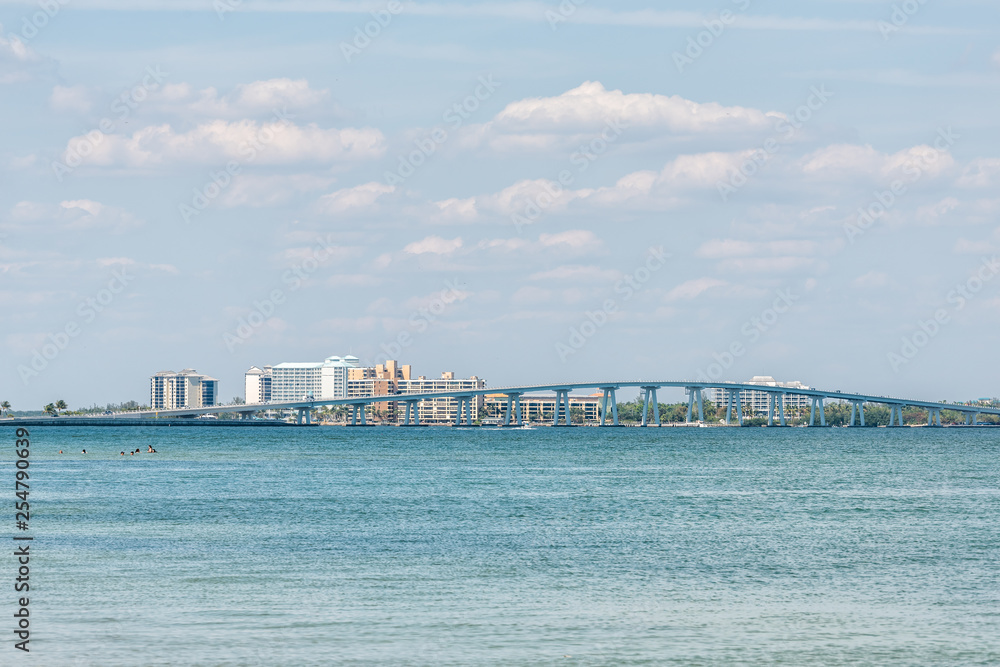 Sanibel Island, USA Bay during sunny day with toll bridge causeway bridge highway road and cars in traffic holiday vacation destination in Florida people swimming