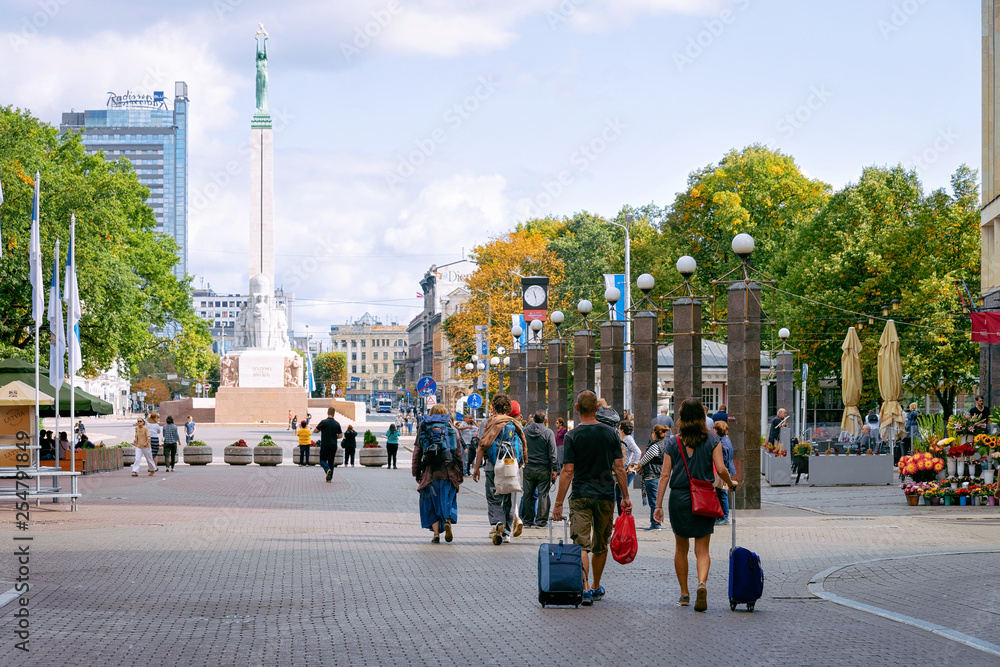Obraz premium People with luggage bags at Liberty square in Riga