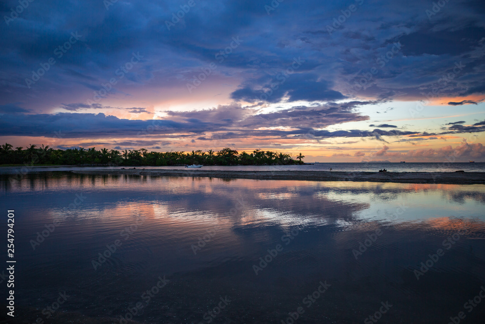 Bright and colorful sunset in Fiji after heavy rain with lots of reflections