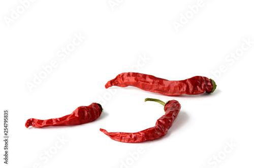 Three dried red chili peppers isolated on a white background