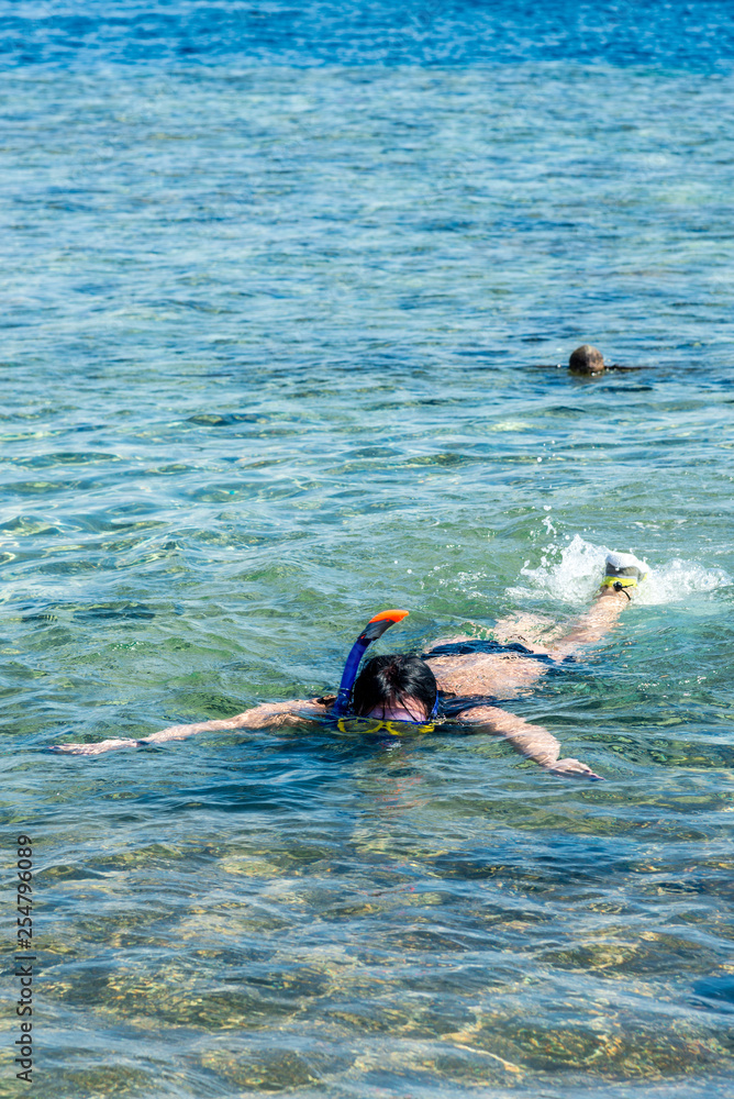 Travel and leisure, a girl with black hair, in a mask with a pipe snorkels