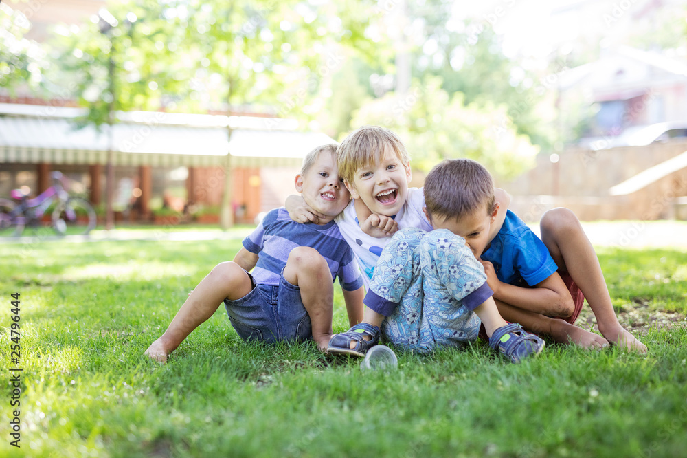 Three happy young boys in summer park