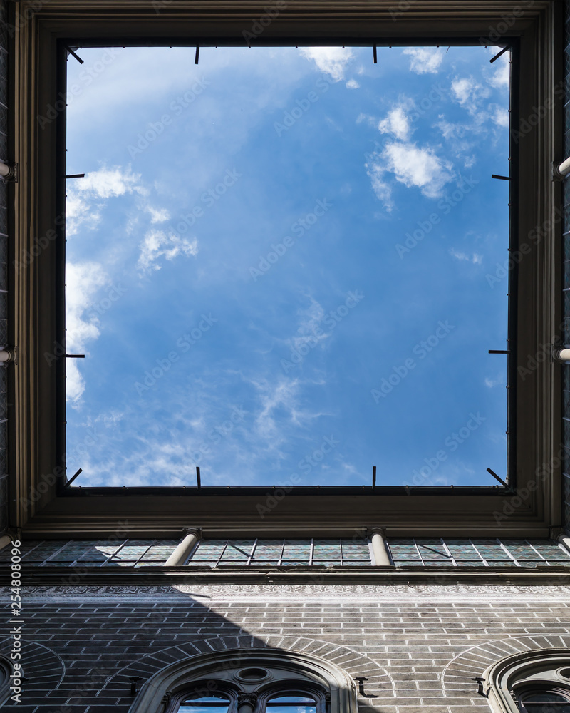 Window to the sky. View upstairs from courtyard of vintage house in Florence, Italy. Very interesting angle. Square frame with falling sun rays. Window to the sky. View upstairs from courtyard of vintage house in Florence, Italy. Very interesting angle. Square frame with falling sun rays.