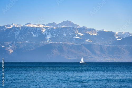 Boat on the Geneva lake with alps mountain in background.