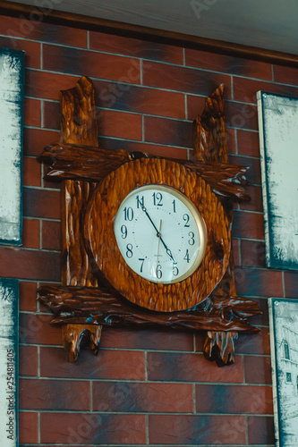 Wooden clock on a brick wall