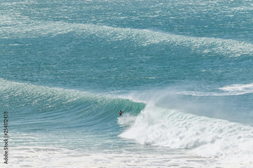 man surfer catching big wave tropical emerald green ocean from top of the hill Kirra beach coolangatta gold coast queensland Australia 