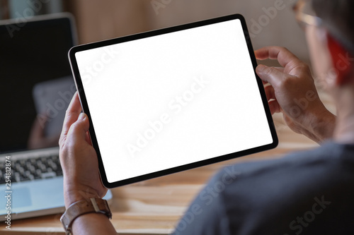 Man holding and using blank screen tablet photo