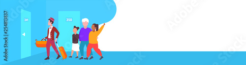 mix race tourists family with african american bellboy carrying luggage to guest room hospitality staff service concept modern hotel corridor interior full length horizontal