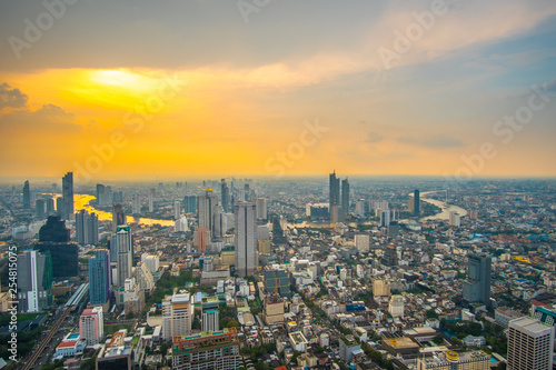 Sunset skyline over Bangkok city central business downtown with some partial rainy clouds. © Sthapana S.