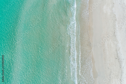 Aerial view of sandy white beach and turquoise waters in summer