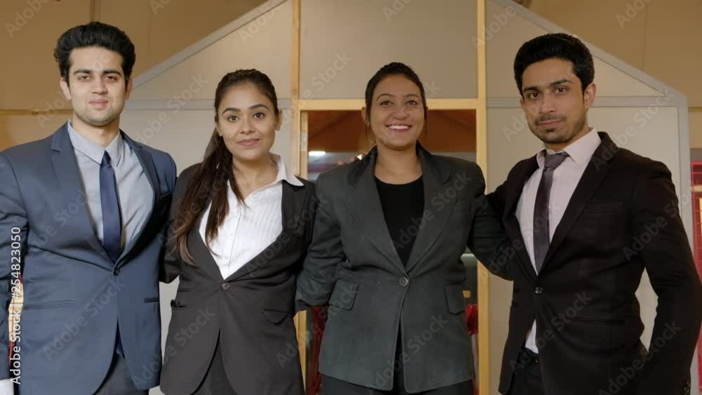 Focus shift on successful young business women and men huddled together as they smile and look at camera with authority, leadership and confidence Focus shift on successful young business women and men huddled together as they smile and look at camera with authority, leadership and confidence