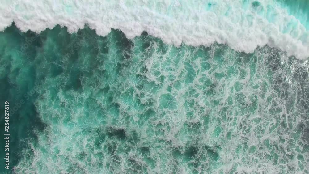 Top view of ocean blue waves crashing coastline drone footage Top view of ocean blue waves crashing coastline drone footage