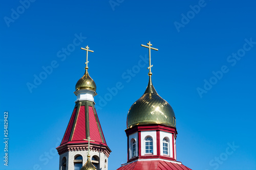 The domes of the Orthodox church against the blue sky, beautiful golden