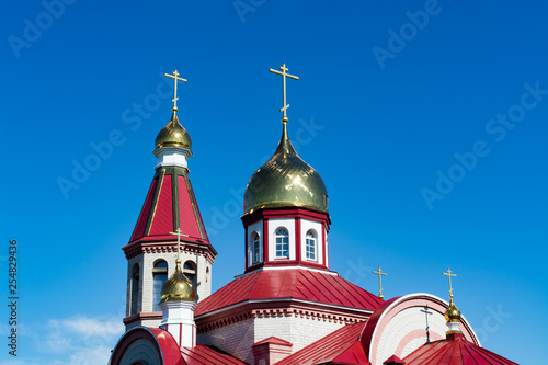 The domes of the Orthodox church against the blue sky, beautiful golden