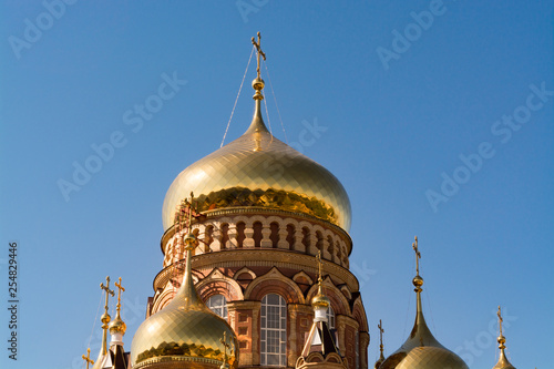 The domes of the Orthodox church against the blue sky, beautiful golden