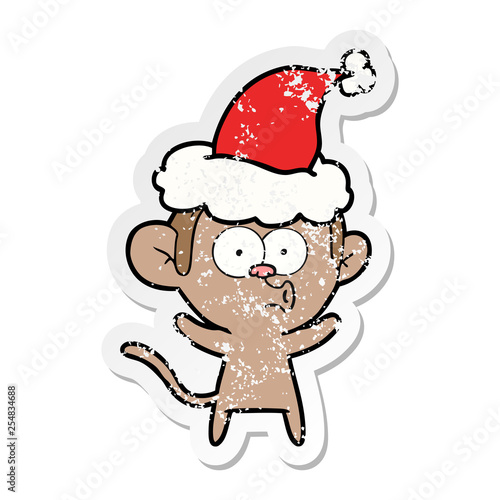 distressed sticker cartoon of a surprised monkey wearing santa hat
