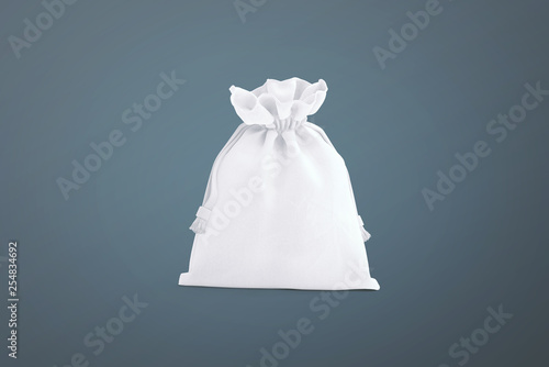 White drawstring bag on dark background. Fabric cotton small bag. Isolated pouch.