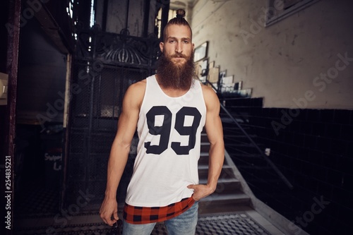 Muscular young bearded man in staircase