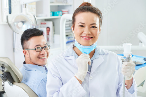 Dentist using dental drill for treatment