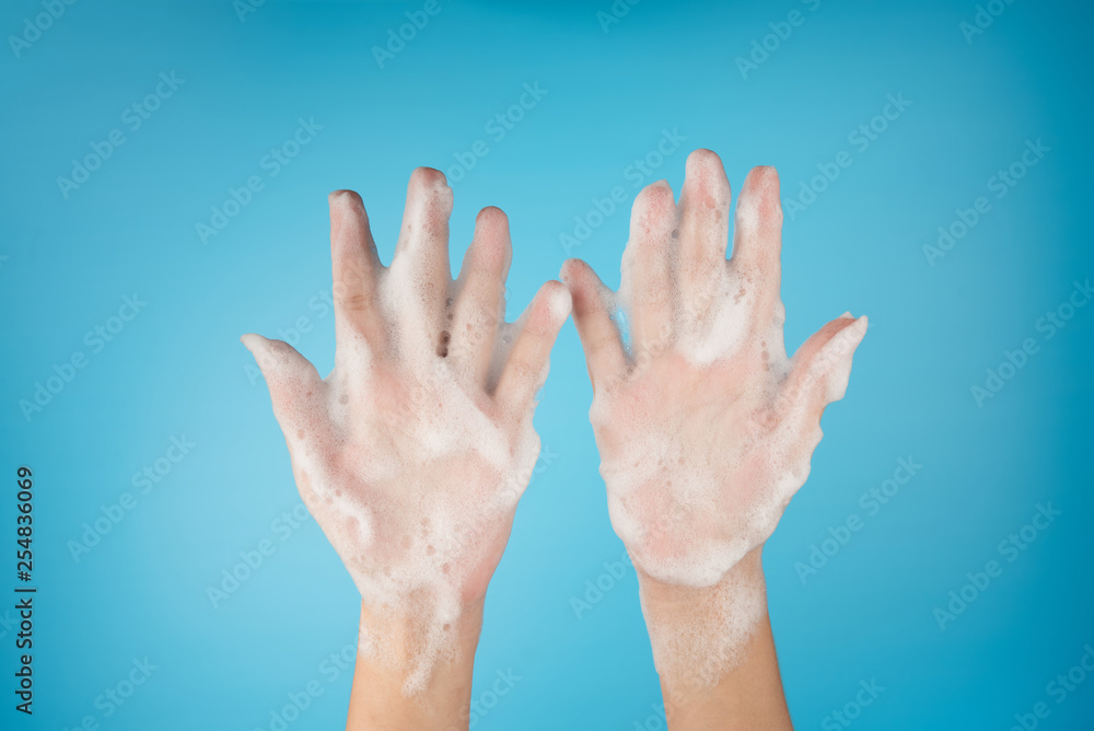 Bubble foam froam soap on hands female on top view isolated on blue background Bubble foam froam soap on hands female on top view isolated on blue background