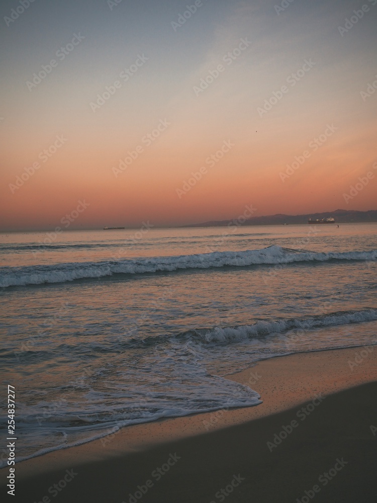 Sandy beach in Manhattan beach in Los Angeles at sunrise, beautiful romantic pink sky
