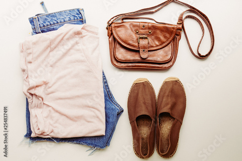 Ideal clothes for summer outfits: a shirt, jeans, a bag, shoes. View from above.