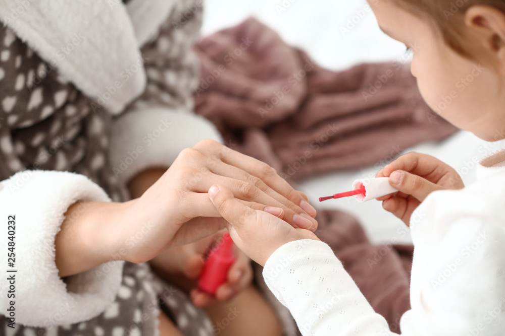 Cute daughter with mother making manicure at home Cute daughter with mother making manicure at home